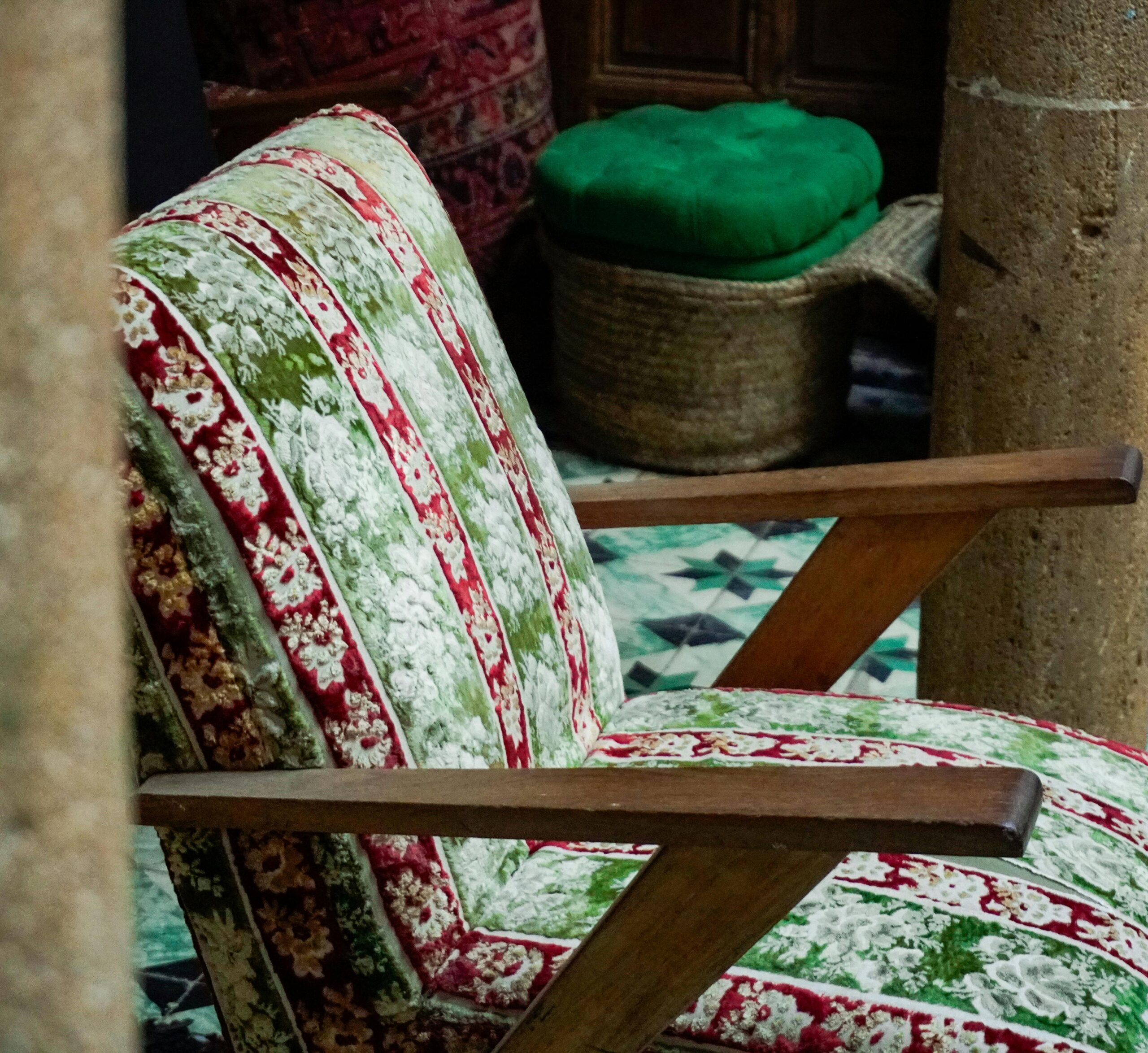 A beautifully patterned vintage armchair in a traditional Moroccan setting, showcasing rich textures and colors.